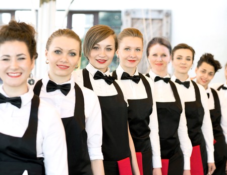 group of waiters at a prestigious restaurant standing in the colの写真素材
