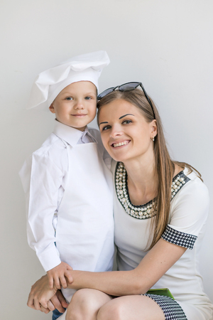 Portrait of happy mother and child early age in the form of a chefの写真素材
