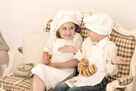 Portrait of happy brother and sister as a chef discussing recipesの写真素材