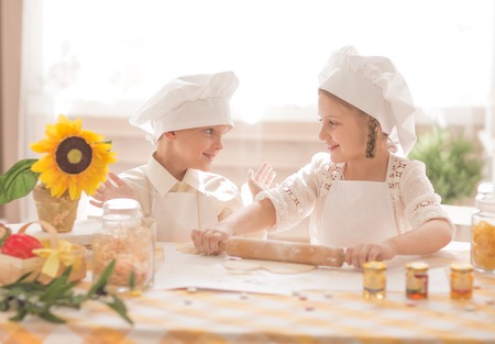 happy little children in the form of a chef to prepare delicious foodの写真素材