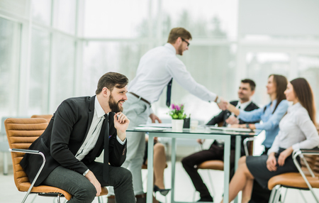 photo of the boss on the background of the handshake between the workplace in a modern officeの写真素材