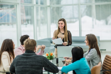 business team discussing marketing schemes in the workplace on the background of the companys employeesの写真素材