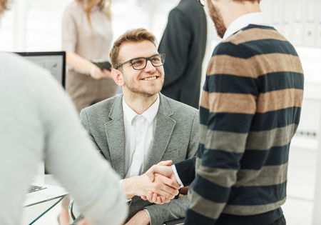handshake colleagues near the workplace in the modern office.の写真素材