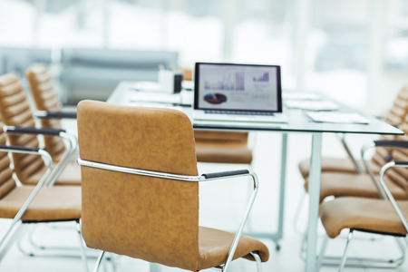 open laptop computer with financial charts on the table with the Manager in a modern office. the photo is a blank space for your textの写真素材