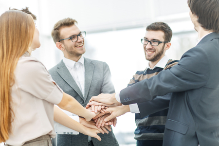 concept of success in business: friendly business team standing in a circle and joining his hands togetherの写真素材