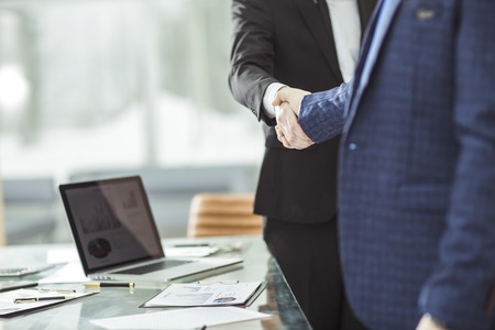 success concept in business - handshake of business partners on the background of the workplaceの写真素材