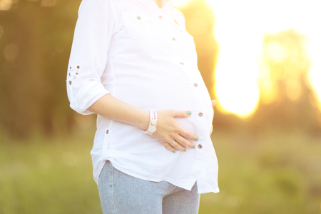 pregnant woman on a walk in the Park on a Sunny dayの写真素材