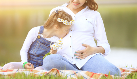 concept of maternity - pregnant mother and little daughter havinの写真素材