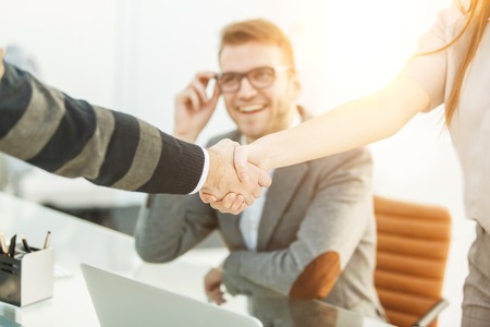 handshake of business partners on the background of the professional employeeの写真素材