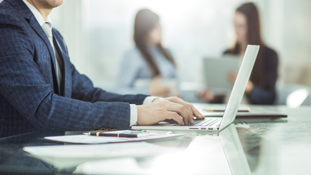 successful businessman working on laptop with financial data at the workplace in a modern office.の写真素材