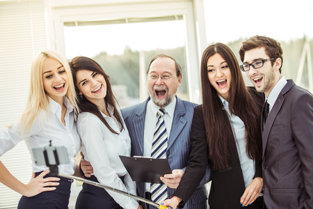 happy business team makes a selfie standing near the window in the officeの写真素材