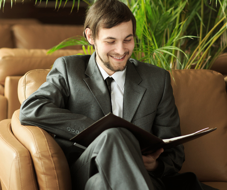 successful businessman studies the working papers in the chair the modern officeの写真素材