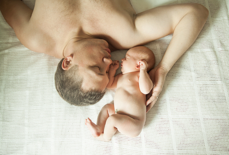 concept of family happiness - sleeping father and newborn baby.の写真素材