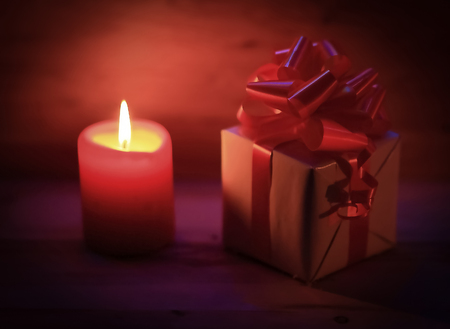 two candles and Christmas gift on holiday background.の写真素材