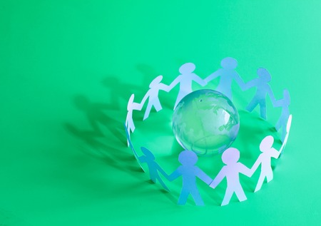 group of paper men standing around the glass globeの写真素材