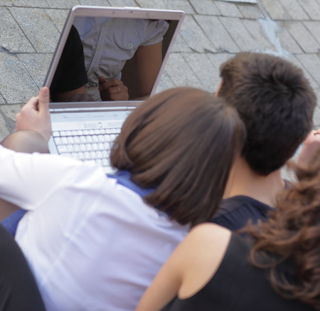 rear view. the group of friends of students with a laptopの写真素材