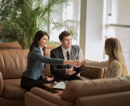 handshake of the manager and the client after the contract discussion in the lobby of the modern officeの写真素材