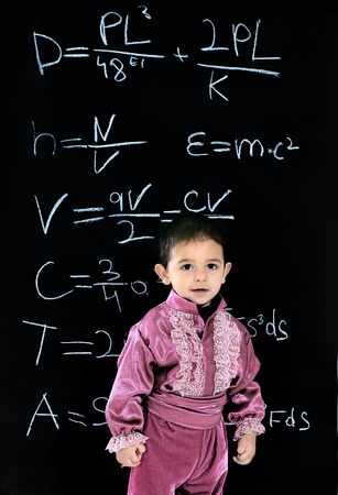 little Gypsy boy in national costume standing near school blackboardの写真素材