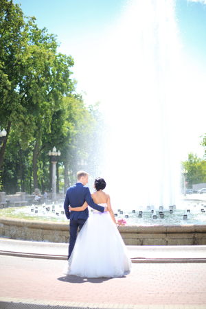 rear view.bride groom standing in front of the fountainの写真素材