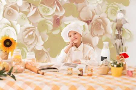 cute little baby is preparing tasty meals in the kitchenの写真素材
