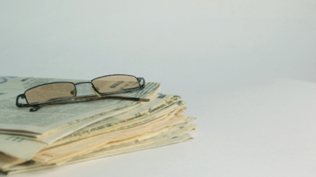 stack of Newspapers and glasses isolated on whiteの写真素材