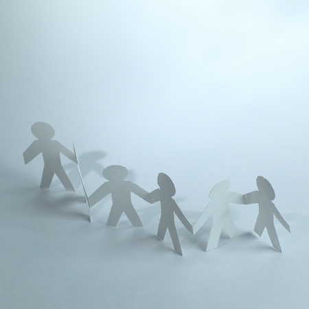 group of paper men holding each others handsの写真素材