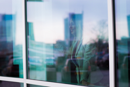 Successful woman is looking out from the window of her personal office
