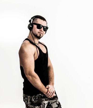 emotional and charismatic DJ - rapper with headphones on a whiteの写真素材