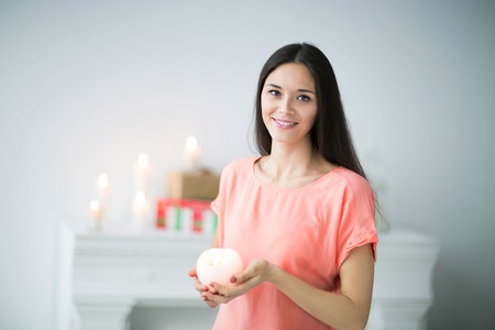 portrait of beautiful young woman with Apple on bright backgroundの写真素材