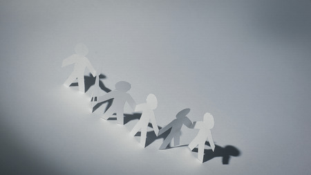 group of paper men holding each others handsの写真素材