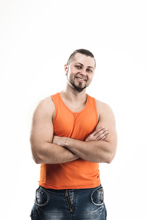 portrait of a sporty guy - bodybuilder in jeans and orange t-shirtの写真素材