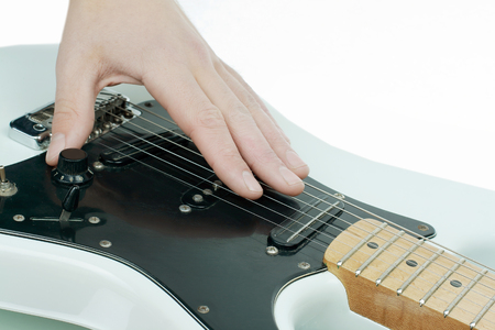 closeup.the hand of the musician stroking the strings of a guitarの写真素材
