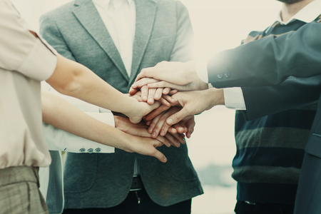 concept of success in business: friendly business team standing in a circle and joining his hands...