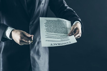 closeup of a businessman holding a pen and a document with the terms of the contract.の写真素材