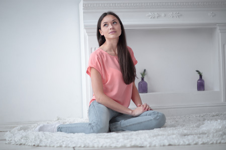 close up.young woman sitting on white carpet in living roomの写真素材