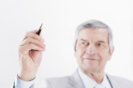 Mature businessman showing a pencil on the copy space.の写真素材