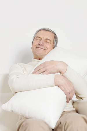 elderly man with a comfortable pillow.isolated on whiteの写真素材