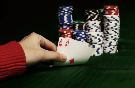 closeup. casino chips and playing cards in the players hand.