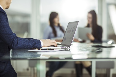 financial managers working on laptop with financial data at the workplace in a modern officeの写真素材