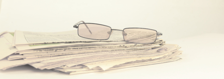 stack of Newspapers and glasses isolated on whiteの写真素材