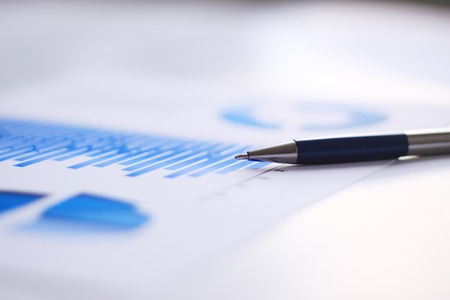 business background: financial chart and pen on office workplaceの写真素材
