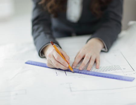 closeup.female architect working with blueprints in the officeの写真素材