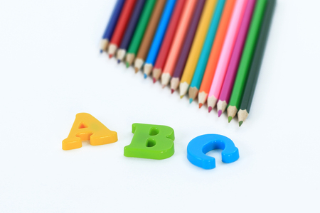 colored pencils and letters of the alphabet on a white background .photo with copy spaceの写真素材