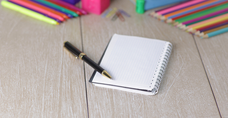 Notepad, pen and school supplies on wooden background.photo with copy spaceの写真素材