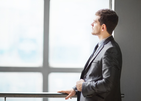 Portrait of smiling handsome businessman looking out the windowの写真素材