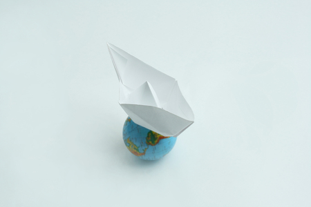 paper boat on the globe.isolated on a white background.の写真素材