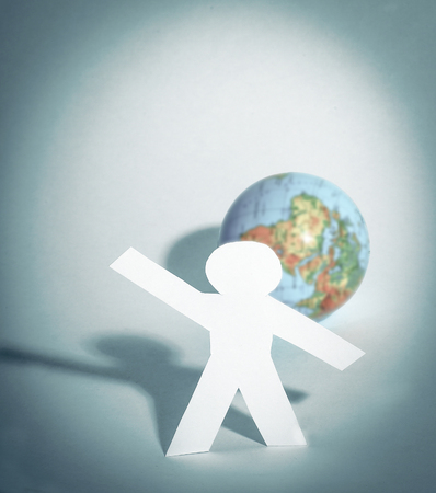 Stylish paper man standing near the globeの写真素材