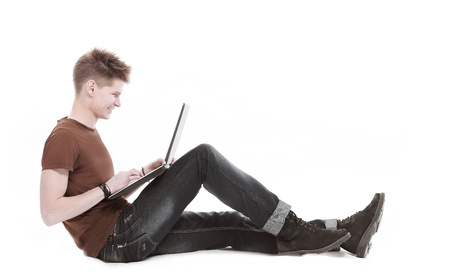 Handsome young relaxing man using laptop and lying on the sofaの写真素材