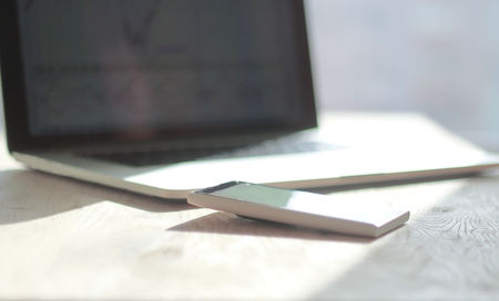 close up. blurred image of a mobile phone and laptop on the desktop