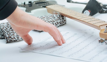 closeup of a guitarist touching sheet music .isolated on a white background.の写真素材